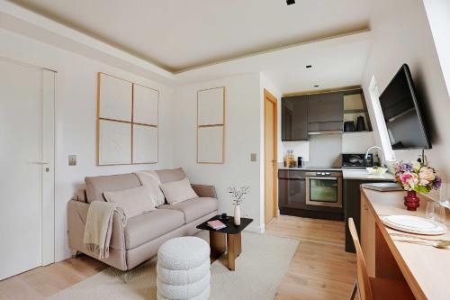 uma sala de estar com um sofá e uma cozinha em Chic Parisian Getaway 4P1BR - Victor Hugo em Paris