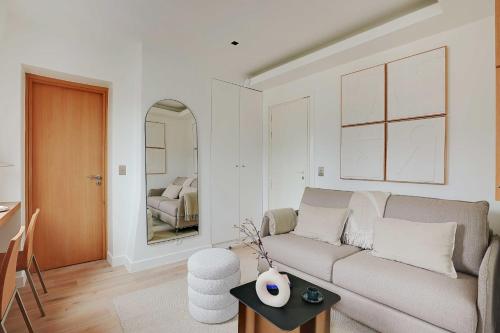 a living room with a couch and a mirror at Chic Parisian Getaway 4P1BR - Victor Hugo in Paris