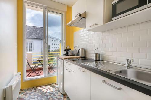 une cuisine avec un évier et une grande fenêtre dans l'établissement Aristide#3 - Studio Lumineux avec sa jolie terrasse, à Saint-Nazaire