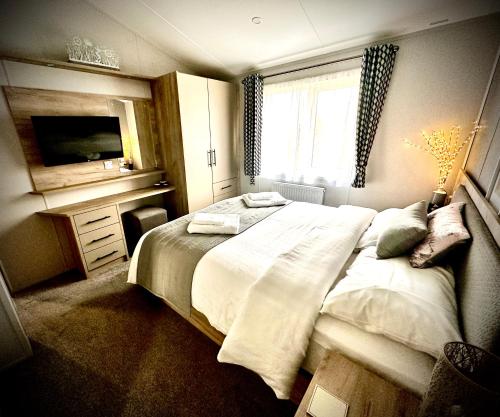 a bedroom with a large bed and a window at C-Scape Lodge in Newquay