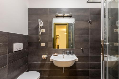 ein Badezimmer mit einem Waschbecken, einem WC und einem Spiegel in der Unterkunft La Riviere Guesthouse Trastevere in Rom