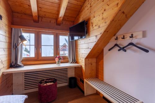 ein Zimmer in einem Blockhaus mit einer Bank und einem Fenster in der Unterkunft Sonne Andermatt Swiss Quality Hotel in Andermatt