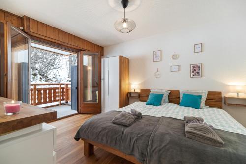 - une chambre avec un grand lit et des oreillers bleus dans l'établissement Appartement chaleureux à Ovronnaz, à Ovronnaz