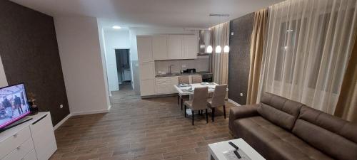 a living room with a couch and a table and a kitchen at Lux Apartmani Novi Park in Vrdnik