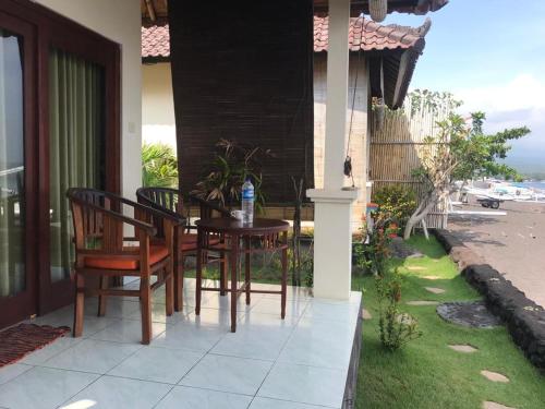 a patio with a table and chairs on a house at Tambun Sari Beach Homestay in Amed