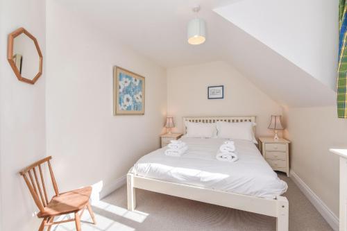 a bedroom with a white bed and a chair at Sea Way in Middleton-on-Sea