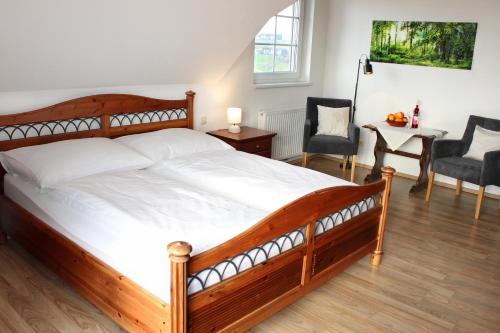 a bedroom with a wooden bed and a table and chairs at Pension Lammerhof in Unterlamm