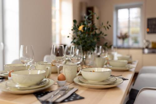 a table with plates and glasses and a christmas tree at ErholungNOW in Bispingen