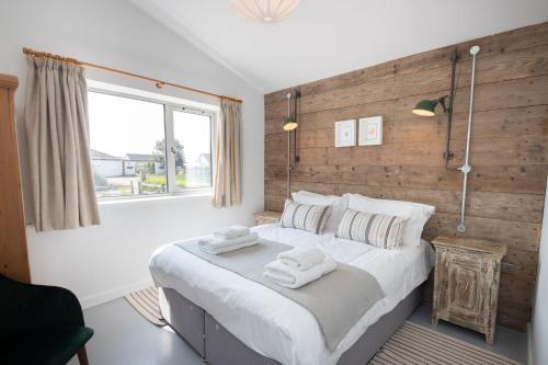 a bedroom with a large bed with two towels on it at Sea Breezes in Pagham