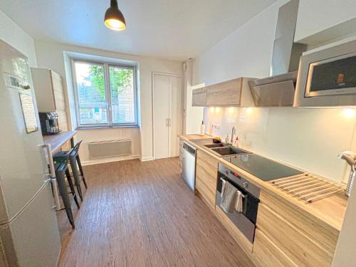 a kitchen with a sink and a stove top oven at Gîte cosy avec Jacuzzi classé 3 étoiles in Poncin