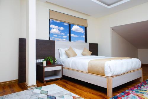 a bedroom with a large bed and a window at Sarovar Residency Serviced Apartment Hotel in Jawlakhel