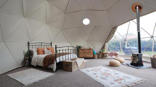 ein Schlafzimmer mit einem Bett in einem Zelt in der Unterkunft Luxury Dome with Private Wood-Fired Hot Tub in Oxford