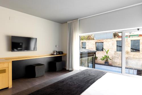 a bedroom with a tv and a large window at Onix Liceo in Barcelona