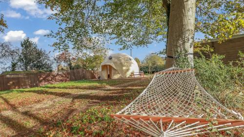 a hammock in a yard next to a tree at Luxury Dome with Private Wood-Fired Hot Tub in Oxford