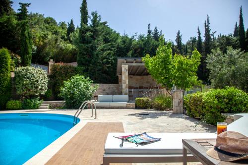 un patio trasero con piscina y una casa en SAZ VILLAS, en Sivota