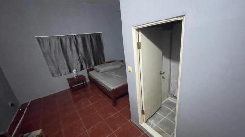 a room with a bed and a window and a door at Siem Reap Holiday Guest House or Motel in Siem Reap