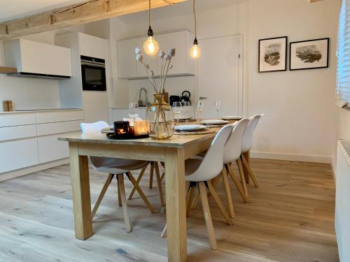 cocina y comedor con mesa de madera y sillas en Haigis Lodge 2, en Annaberg im Lammertal