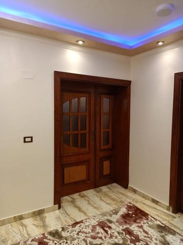 a room with a wooden door and a blue ceiling at Nile Riviera in Mansoura in Mansoura