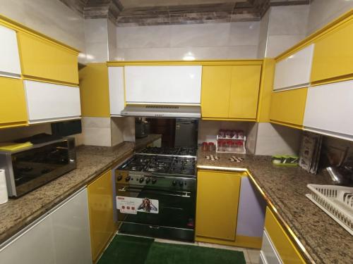 a kitchen with yellow cabinets and a stove at Nile Riviera in Mansoura in Mansoura