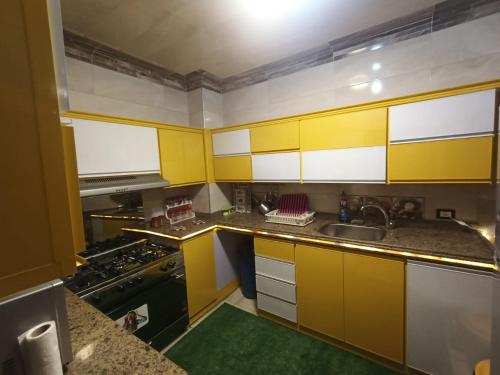 a kitchen with yellow cabinets and a sink at Nile Riviera in Mansoura in Mansoura