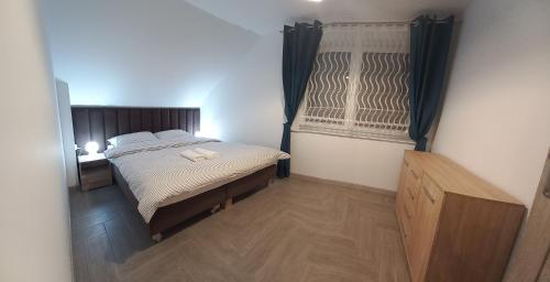 um pequeno quarto com uma cama e uma janela em Apartament Wierchy em Klikuszowa