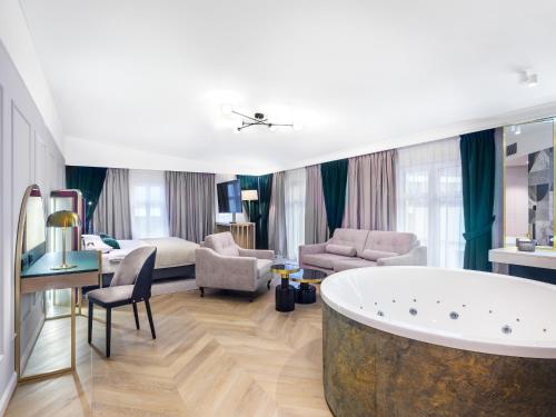 ein Wohnzimmer mit einer großen Badewanne im Zimmer in der Unterkunft Golden Queen Aparthotel in Krakau