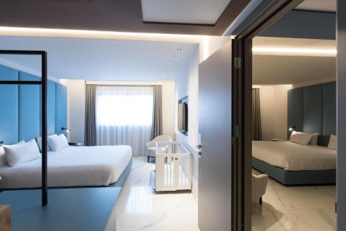 a hotel room with two beds and a mirror at Mercure St. Julian's Malta in St Julian's
