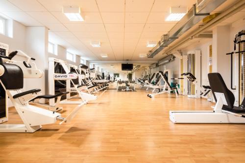 a gym with a row of treadmills and machines at Lapland Hotels Äkäshotelli in Äkäslompolo