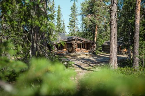a log cabin in the middle of a forest at Lapland Hotels Äkäshotelli in Äkäslompolo