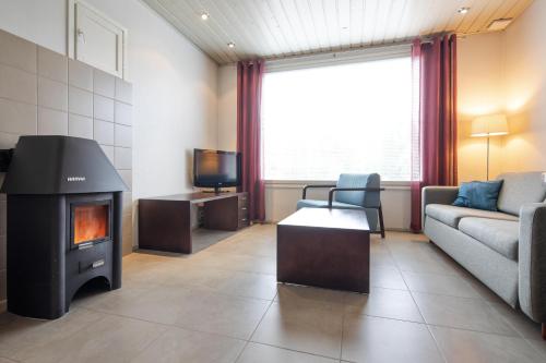 a living room with a couch and a fireplace at Lapland Hotels Äkäshotelli in Äkäslompolo