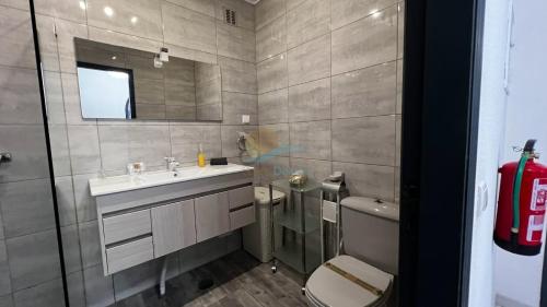 uma casa de banho com um lavatório, um WC e um espelho. em Oura Descobrimentos by Sunny Deluxe em Albufeira