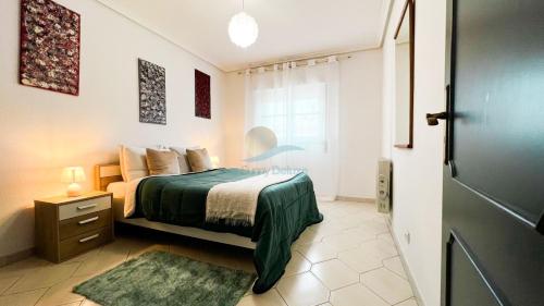 um quarto com uma cama com um cobertor verde em Oura Descobrimentos by Sunny Deluxe em Albufeira