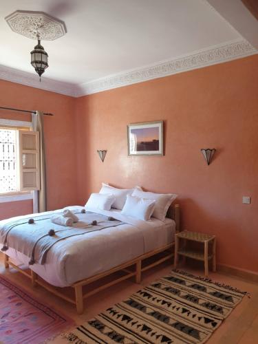 a bedroom with a large bed with orange walls at Dar Ajgal in Dourtane