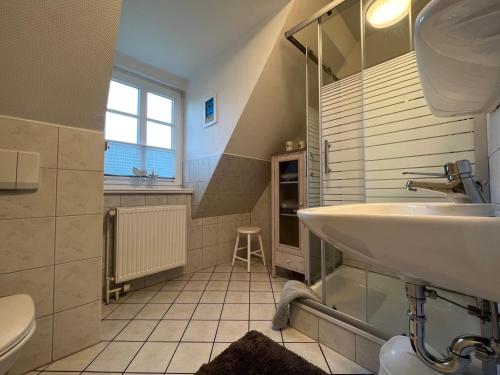ein Bad mit einem Waschbecken und einem WC in der Unterkunft Greggersen - Whg 1 in Nieblum