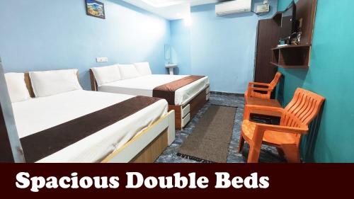 een kleine kamer met 2 bedden en een stoel bij Hotel MG INN Kanipakam in Kanipakam