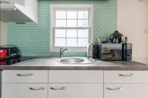 a kitchen counter with a sink and a window at Valkenbosch - De Pimpel 12 in Oisterwijk