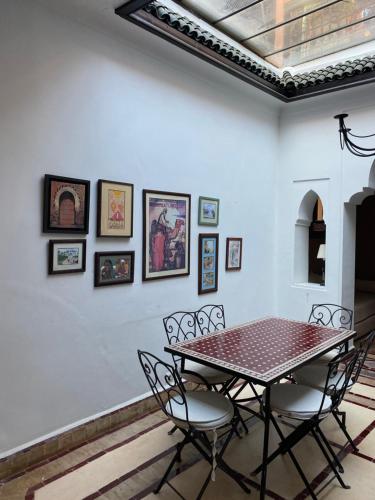 comedor con mesa y sillas en Riad au cœur de la médina loué entièrement avec ménage et petit déjeuner compris, en Marrakech