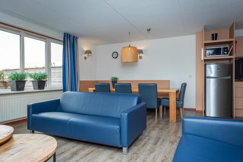 a living room with a blue couch and a table at Veluwe Strandbad Elburg in Elburg
