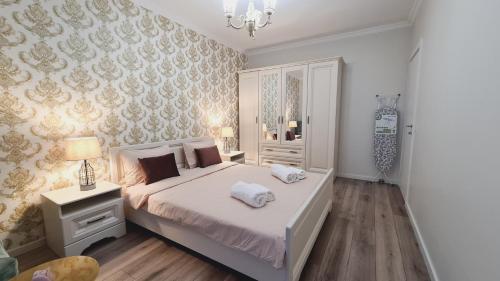 una camera da letto con un grande letto bianco e un lampadario a braccio di 5* luxury near Avram Iancu sq New. Private parking a Cluj-Napoca
