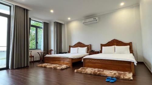 a bedroom with two beds and a large window at THANH BÌNH HOTEL, Bình Long in Binh Long