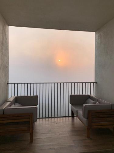 a living room with two beds and a fence at Studio Apt with Rooftop Panoramic views @ Dabolim in Vasco Da Gama