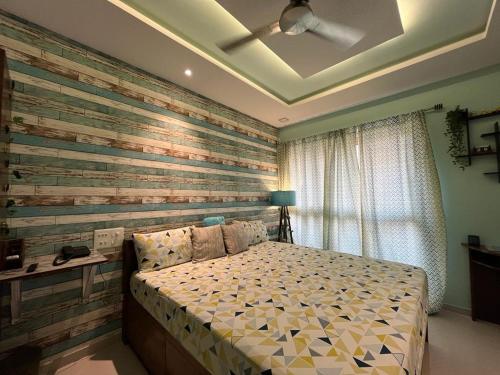 una camera da letto con un letto e una parete con accenti in legno di Studio Apt with Rooftop Panoramic views @ Dabolim a Vasco da Gama