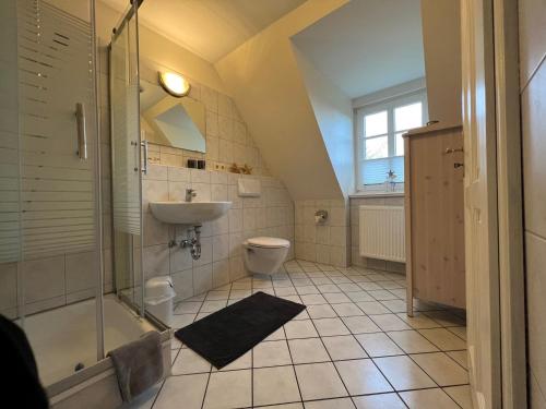 a bathroom with a shower and a toilet and a sink at Greggersen - Whg 2 in Nieblum