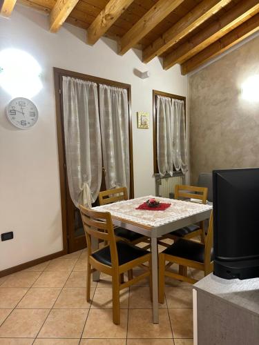 comedor con mesa, sillas y TV en Appartamento Fiordaliso 1, en Montichiari