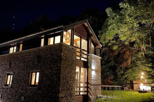 un edificio de ladrillo con ventanas por la noche en Le Belle-Vue, en La-Roche-en-Ardenne