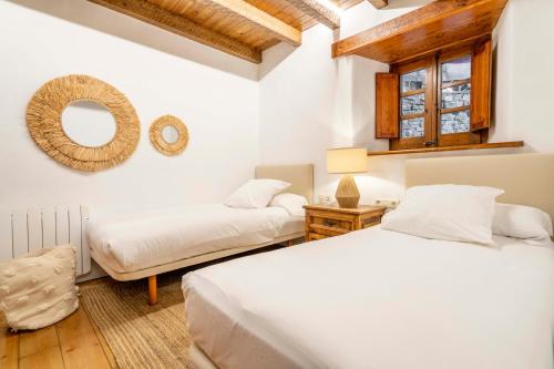a bedroom with two beds and a mirror on the wall at Casa Baciver by FeelFree Rentals in Garós