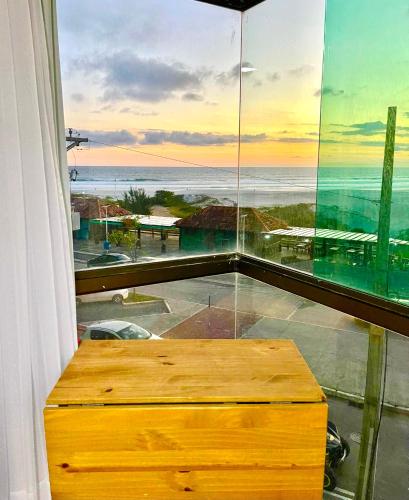 a room with a window with a view of the ocean at Loft Luxo Vista Mar Orla Praia Grande in Arraial do Cabo