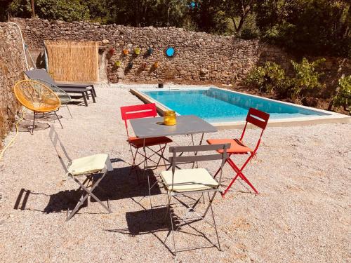 un groupe de chaises et une table à côté d'une piscine dans l'établissement Gites entre 2 rives, à Montolieu