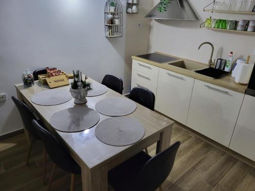 cocina con mesa con sillas y fregadero en Kuća za odmor Potjeh en Slavonski Brod