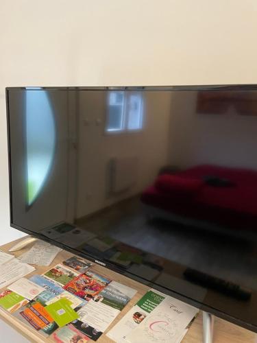 une télévision à écran plat installée au-dessus d'une table. dans l'établissement Superbe appartement terrasse wifi, à Paroy-sur-Tholon